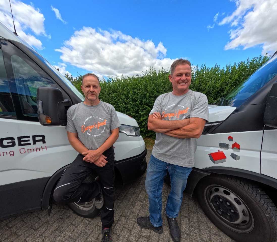 Stephan Liehr (links) und Remo Dinger (rechts) vor den Firmenfahrzeugen